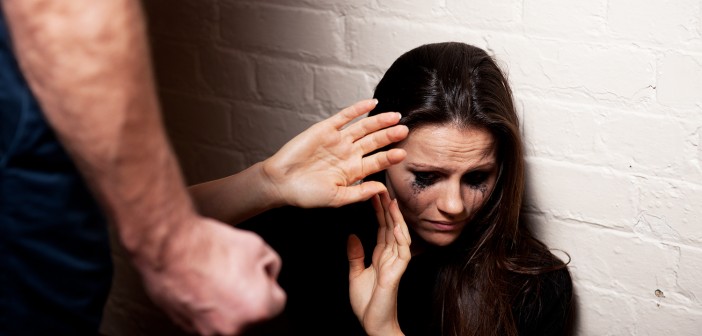 Young woman trying to protect herself from a man's clenched fist.